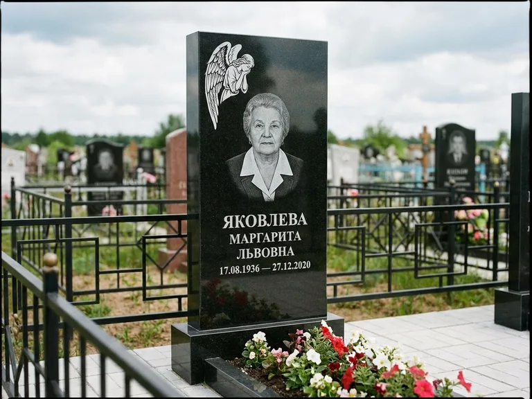 Памятник с гравировкой ангела — белая гравировка скорбящего ангела над портретом, работа «Яковлева» в Норильске