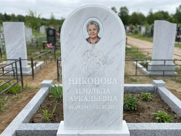 Памятник с гравировкой ангела — белая гравировка скорбящего ангела над портретом, работа «Гордеева» в Норильске