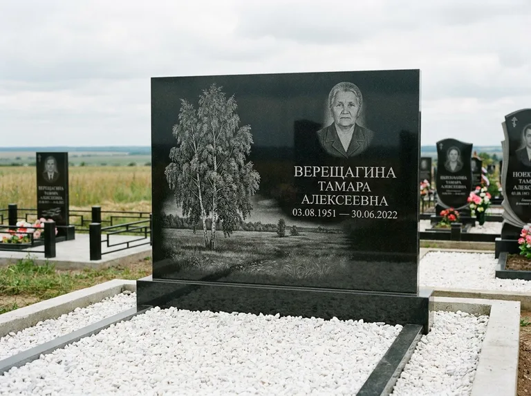 Памятник с гравировкой берёзы: широкая горизонтальная стела — берёза у поля, простор до горизонта, белая мраморная крошка с бордюром, работа «Верещагина» в Норильске