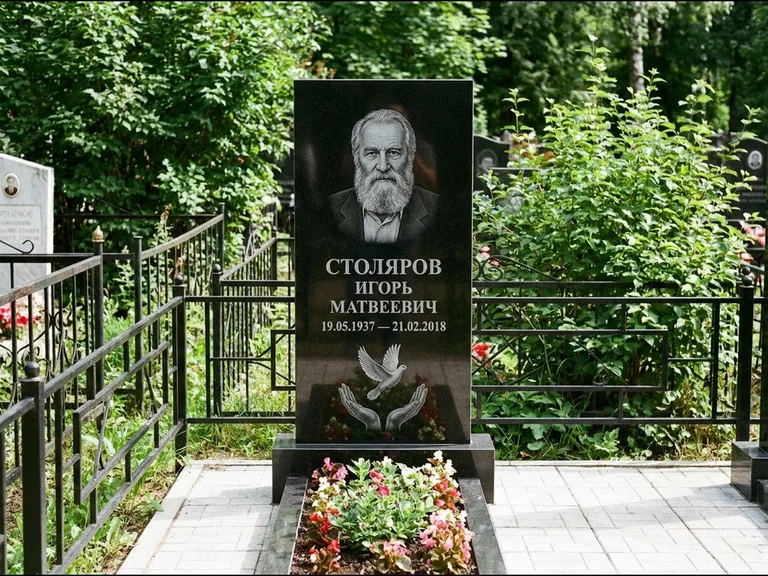 Памятник с гравировкой голубей — гравировка голубя над раскрытыми ладонями внизу стелы, работа «Столяров» в Норильске