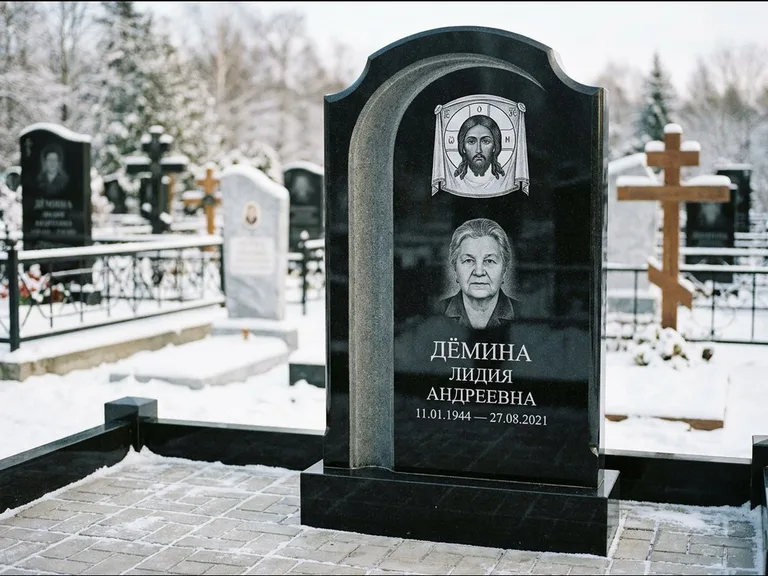 Памятник с гравировкой иконы: гранёный восьмиугольный обелиск с крестом — гравировка Николая Чудотворца, семейный участок с гранитной скамьёй, работа «Зотов» в Норильске
