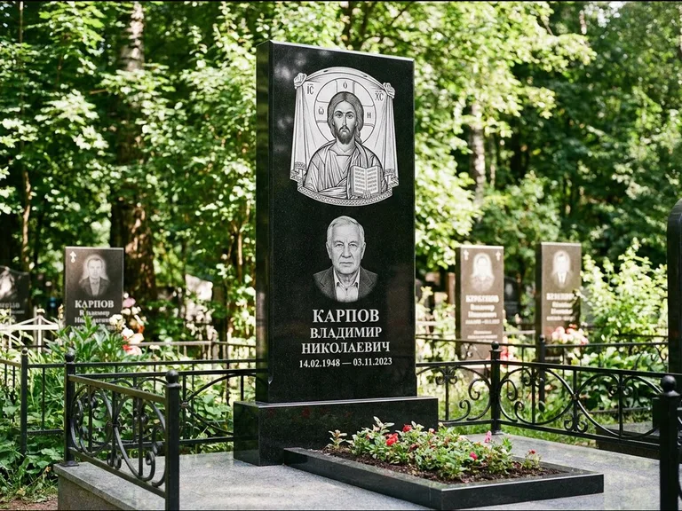 Памятник с гравировкой иконы: широкая двойная семейная стела — золочёный нимб на образе, цветник с красными розами, работа «Воронцова» в Норильске
