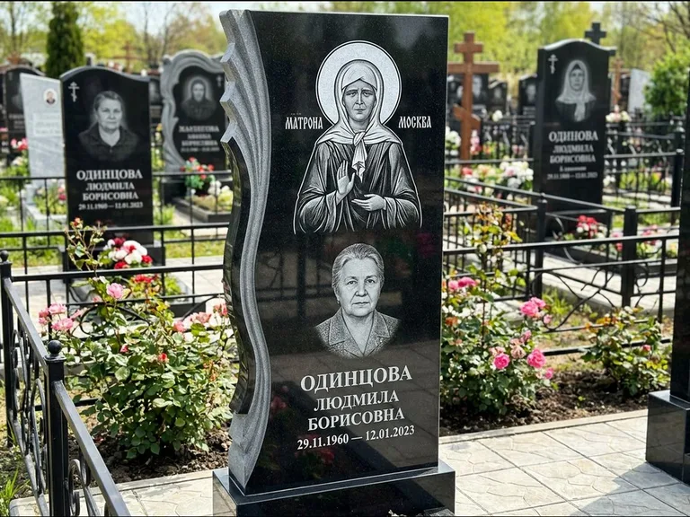 Памятник с гравировкой иконы: ступенчатая двухуровневая стела — Архангел Михаил на стеле, каменная дорожка из плитняка, работа «Одинцов» в Норильске