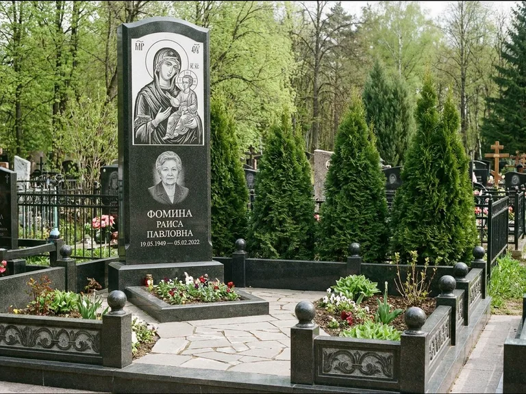 Памятник с гравировкой иконы: высокий гранёный обелиск с крестом-навершием — гравировка образа Матроны Московской, открытый участок без ограды, работа «Третьяков» в Норильске