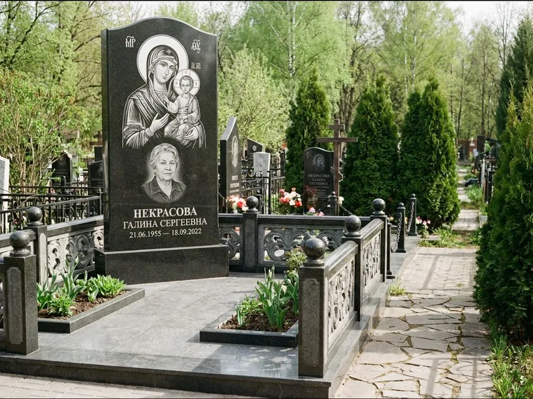 Памятник с гравировкой иконы: полукруглая стела с купольным навершием — Архангел Михаил на стеле, заснеженный зимний участок, работа «Гущин» в Норильске