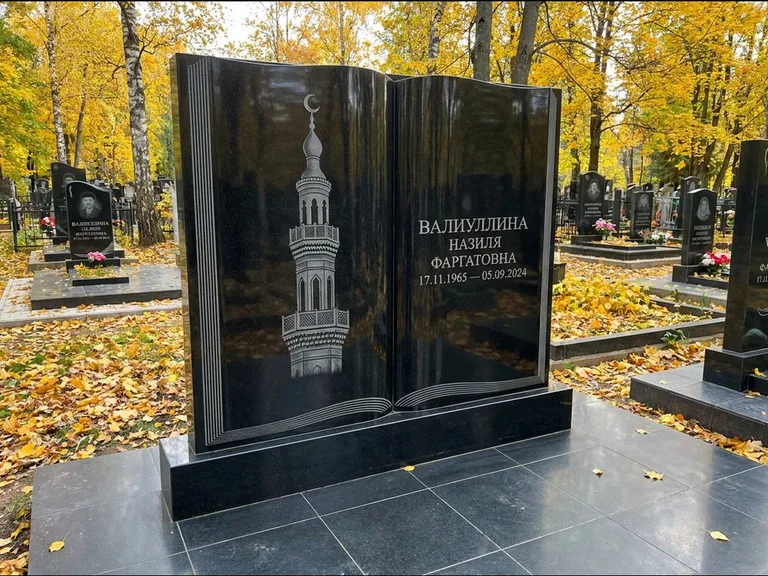 Мусульманский памятник с гравировкой мечети: стела в форме раскрытой книги на подставке — белая гравировка силуэта мечети с минаретами, цоколь тёмной плиткой, работа «Исмаилова» в Норильске