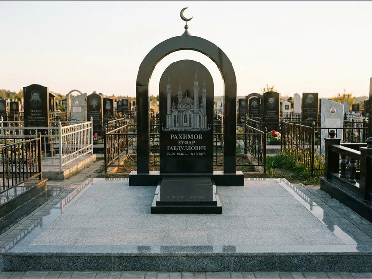 Мусульманский памятник с гравировкой мечети: монументальная стела-арка с полумесяцем на вершине — детализированная гравировка мечети Кул-Шариф, мощёная гранитная площадка с бордюром, работа «Юсупов» в Норильске