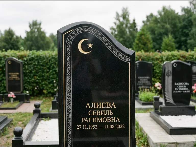 Мусульманский памятник: асимметричная скошенная стела — белая гравировка силуэта мечети с минаретами, живая изгородь из кустарника, работа «Алиева» в Норильске