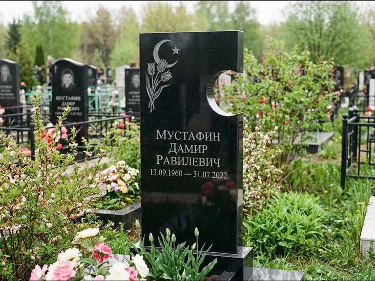 Мусульманский памятник: стела с боковым вырезом в форме полумесяца — гравировка минарета с полумесяцем, низкие кусты в цвету, работа «Мустафин» в Норильске