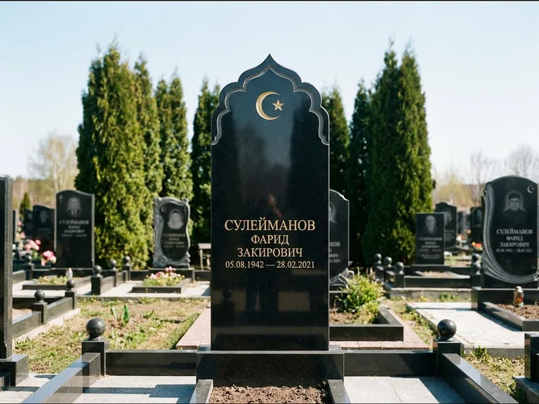 Мусульманский памятник: стела с резным восточным навершием-пиштаком — белая гравировка силуэта мечети с минаретами, высокие туи полукругом, работа «Сулейманов» в Норильске