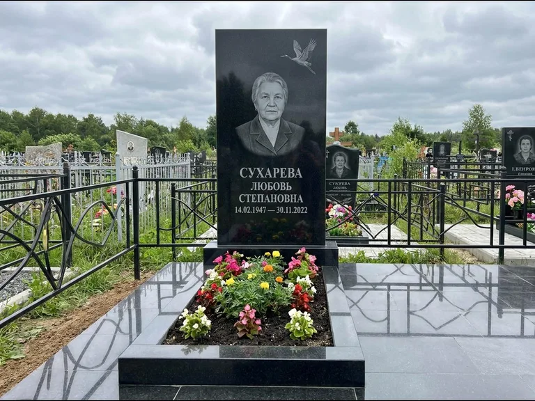 Памятник с гравировкой журавлей — гравировка одиночного летящего журавля над портретом, работа «Сухарева» в Норильске