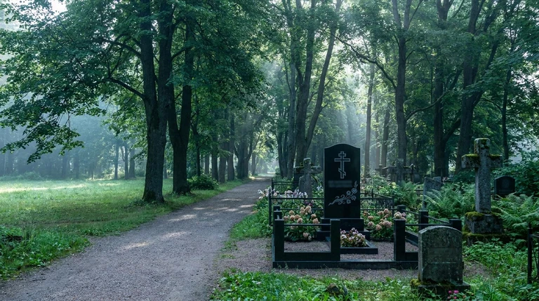 Гранитный памятник тёмного цвета на ухоженном участке Фатеевского кладбища в Челябинске