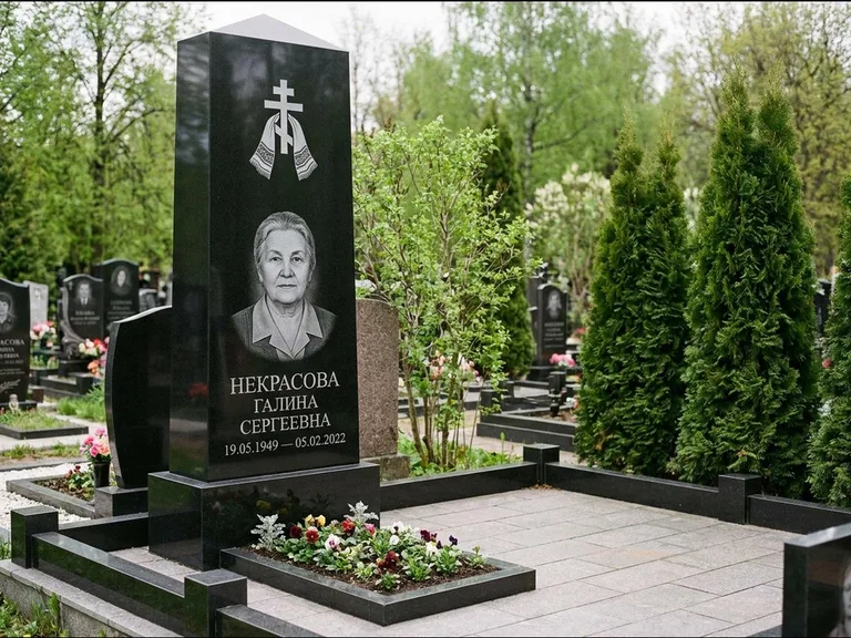 Памятник из чёрного гранита — стела-пилон с ажурным резным крестом, работа «Ерофеева» в Норильске