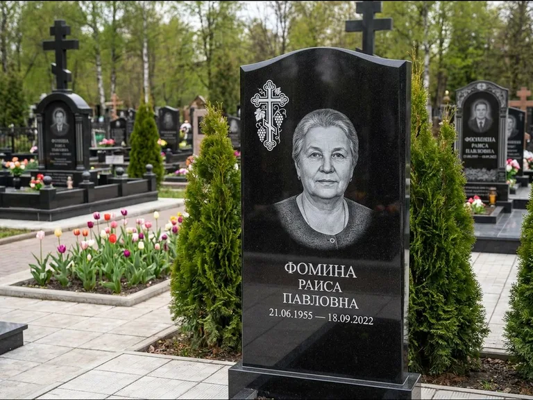 Памятник из чёрного гранита — двухцветная стела с крестом с распятием, работа «Одинцова» в Норильске