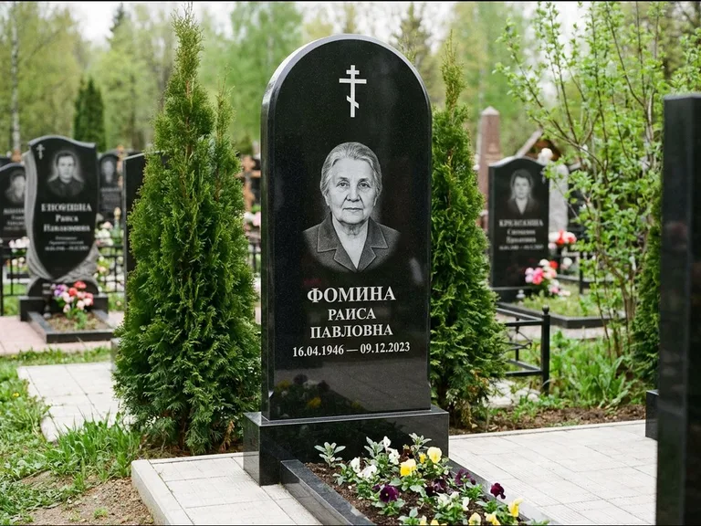 Памятник из чёрного гранита — вертикальная стела с латинским крестом, работа «Некрасова» в Норильске