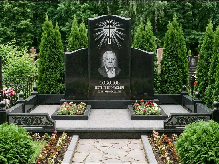 Памятник из чёрного гранита — низкая стела с крестом сбоку с золочёным крестом, работа «Верещагин» в Норильске