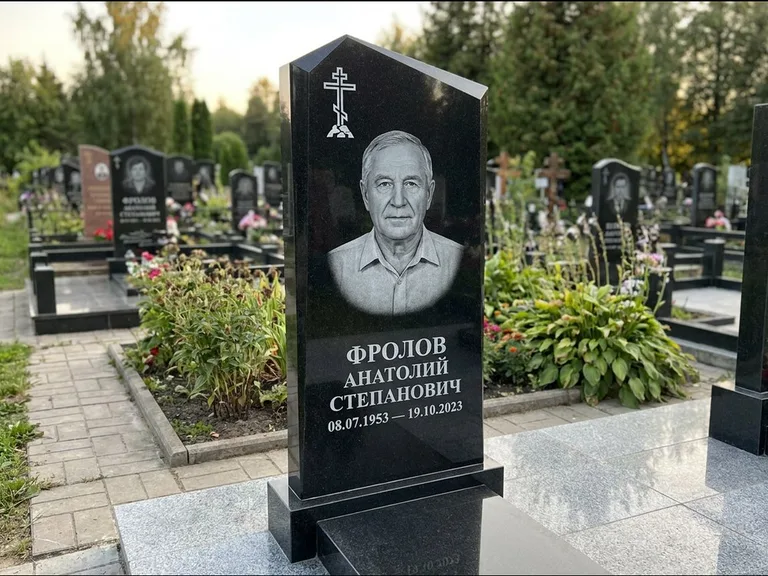 Памятник из чёрного гранита — стела со столиком и скамьёй с крестом на Голгофе, работа «Верещагин» в Норильске