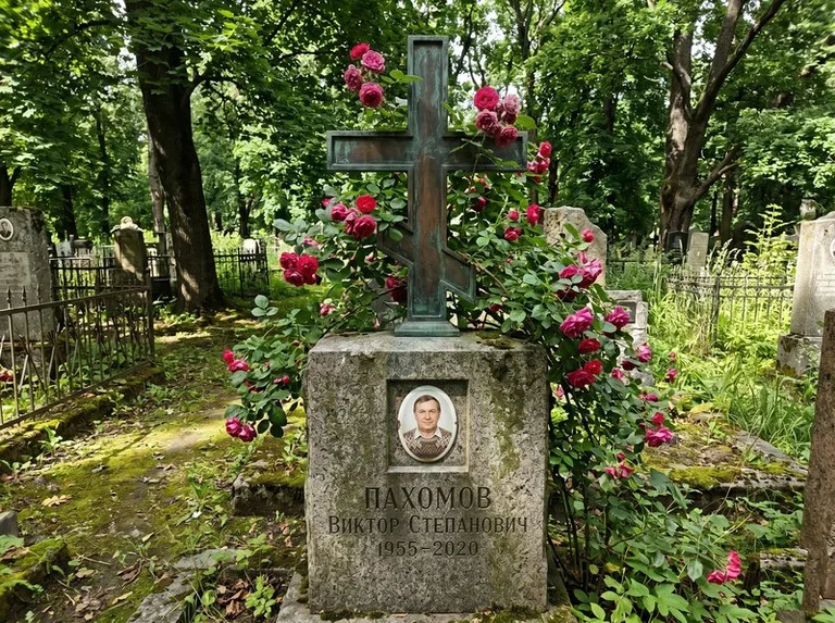 Бронзовый крест с розами на гранитной плите в Норильске