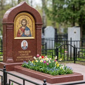 Гранитный памятник в виде раскрытой книги с оградой